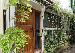 une porte en bois sur une maison ornée de plantes dans l'établissement TOKYO Ebisu! 2adults & 2kids Max4ppl FamilyOK!, à Tokyo