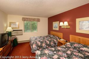ein Hotelzimmer mit 2 Betten und einem TV in der Unterkunft Snowy Owl Inn in Waterville Valley