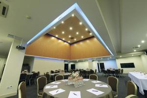 a banquet hall with tables and chairs and a large screen at Timor Plaza Hotel & Apartments in Dili