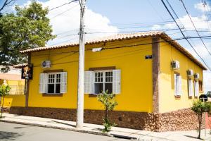 a yellow house on the side of a street at Casarao Hostel - Analandia SP in Analândia