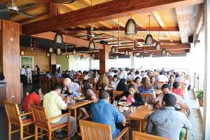 um grupo de pessoas sentadas às mesas de um restaurante em Timor Plaza Hotel & Apartments em Dili