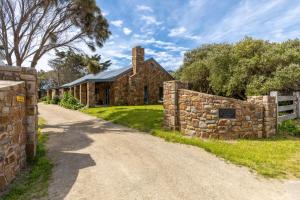 a stone house with a stone fence and a dirt road at Tuscan style ocean beach escape on the Peninsula only 400m to beach in Saint Andrews Beach