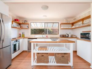a kitchen with a white island in the middle at Casa Moana in Gerringong