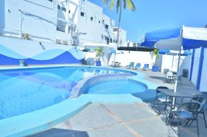 a swimming pool with a table and chairs next to a building at Hotel San Diego in Mazatlán