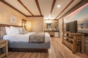 1 dormitorio con 1 cama y TV de pantalla plana en Wanderlust Inn, en Ocean Shores