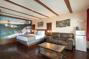 a hotel room with a bed and a couch and a table at Wanderlust Inn in Ocean Shores