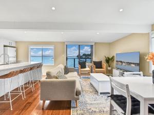 a kitchen and living room with a view of the ocean at The Boat House Absolute Waterfront and Jetty in Morisset East