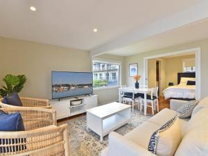 un soggiorno con divano, TV e letto di The Boat House Absolute Waterfront and Jetty a Morisset East