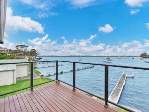 a wooden deck with a view of the water at The Boat House Absolute Waterfront and Jetty in Morisset East