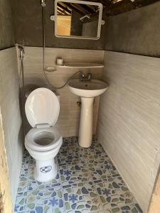 La petite salle de bains est pourvue de toilettes et d'un lavabo. dans l'établissement Mun Homestay, à Ha Giang