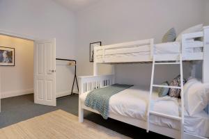 a bedroom with two bunk beds and a door at Beach & Pines Glenelg in Glenelg