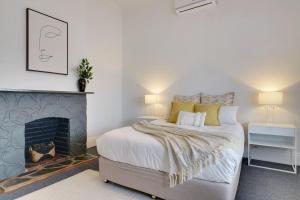 a bedroom with a bed and a fireplace at Beach & Pines Glenelg in Glenelg