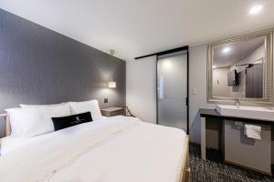 a hotel room with a large bed and a sink at The Barn Tokyo in Tokyo