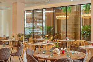 un restaurante con mesas y sillas de madera y ventanas en Pattaya Sea View Hotel - SHA Extra Plus, en Pattaya central
