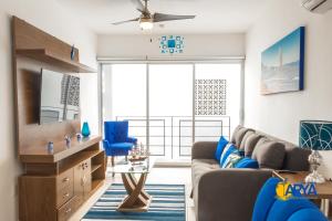 een woonkamer met een bank en een tv bij Disfruta Vallarta, lindo departamento, gran ubicación alberca, nuevo in Puerto Vallarta