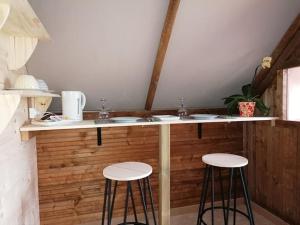 a kitchen counter with two sinks and two stools at Domaine QUIESCIS in Marcellus