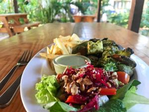a white plate of food on a wooden table at Agonda Cottages in Agonda +60 photos