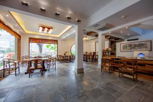 uma sala de jantar com mesas e cadeiras e um balcão em Qingshanshe Hotel em Guilin
