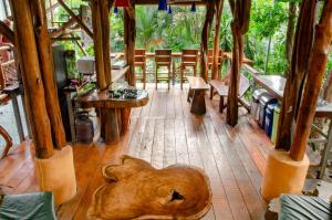 een kamer met houten vloeren en tafels en stoelen bij Tico Adventure Lodge in Sámara