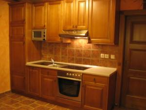 a kitchen with wooden cabinets and a sink and a microwave at APARTMA ARNIKA Rogla, Turistično naselje NUNE RESNIK, RESNIK 110 in Zreče