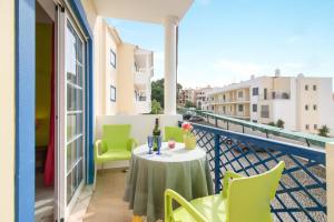 a balcony with a table and chairs and a window at Bosque São José Af in Albufeira