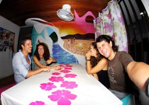 grupa ludzi stojących wokół stołu w obiekcie Blue Almond Hostel - San Andres w mieście San Andrés