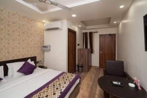 a bedroom with a bed and a table and a desk at HOTEL R R PALACE in Gorakhpur