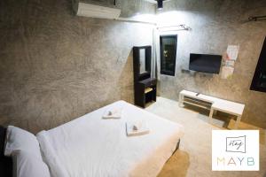 a bedroom with a white bed and a television at STAY MAYB Chiang Mai in Chiang Mai