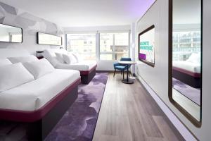 a hotel room with two beds and a table at YOTEL Washington DC in Washington, D.C.