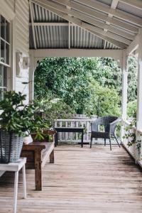 a porch with two benches and a pergola at The Main House @ Poets Lodge in Daylesford