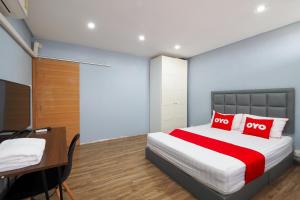 Schlafzimmer mit einem Bett mit roten Kissen und einem Schreibtisch in der Unterkunft OYO 615 Bossa House Hostel & Cafe in Bangkok