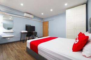 ein Schlafzimmer mit einem großen Bett und einem TV in der Unterkunft OYO 615 Bossa House Hostel & Cafe in Bangkok