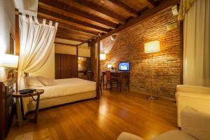 a room with two beds and a brick wall at Hotel Alla Torre in Castelfranco Veneto