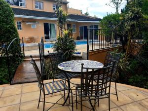 d'une terrasse avec une table et des chaises à côté de la piscine. dans l'établissement Damicha Boutique Lodge, à Ezulwini