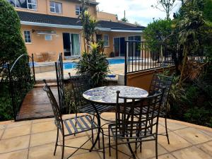 a patio with a table and chairs next to a pool at Damicha Boutique Lodge in Ezulwini