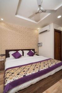 a bedroom with a large bed with purple pillows at HOTEL R R PALACE in Gorakhpur
