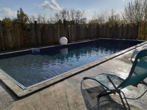 a swimming pool with a chair and a ball in it at Domaine QUIESCIS in Marcellus