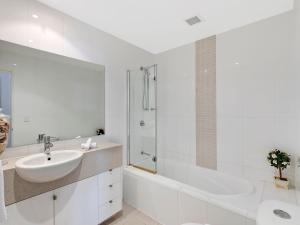 La salle de bains blanche est pourvue d'un lavabo et d'une douche. dans l'établissement Blue Coral Terrace Coast Luxury 31, à Entrance