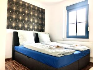 #WORLD Privat Wohnung في شكويديتس: غرفة نوم بسريرين مع شراشف زرقاء ونافذة