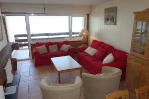 a living room with a red couch and a table at Magrappé MOUNTAIN & CENTER apartments in Veysonnaz