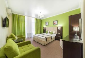 ヴィチャゼヴォにあるHotel Avroraのグリーン ホテル ルーム ベッド1台&ソファ付