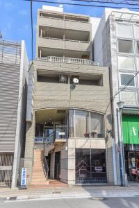um edifício alto com uma escada em frente em COCOSTAY Global Noboricho4F ココステイ グローバル ノボリチョウ4F em Hiroshima