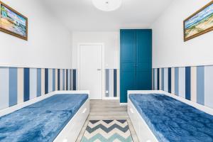 two beds in a room with blue and white walls at Jantar Apartamenty - Bałtycka 6 in Kołobrzeg