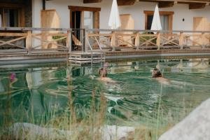 two people are swimming in a swimming pool at Kaiserlodge in Scheffau am Wilden Kaiser