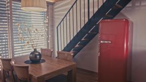 a dining room with a table and a red refrigerator at Hotel Els Caçadors de Ribes in Ribes de Freser