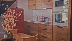a kitchen with wooden cabinets and a table with a vase at Hotel Els Caçadors de Ribes in Ribes de Freser