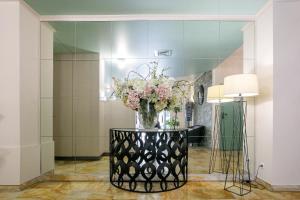 a vase of flowers on a table in a room at Hôtel Spunta Di Mare in Ajaccio