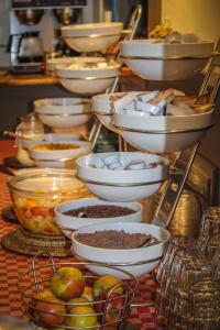 einen Tisch voller Schalen und Teller mit Lebensmitteln in der Unterkunft Hotel 1900 in Bergen