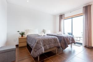 Un dormitorio con una cama y una ventana grande. en Casa Chic, en Vila do Bispo