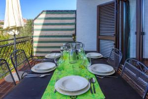 een tafel met borden en glazen op een balkon bij MAKSIM in Crikvenica